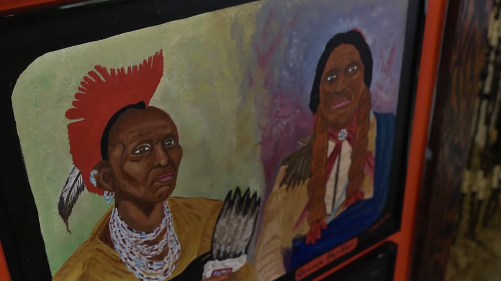 A painting depicting two Native American figures in traditional attire